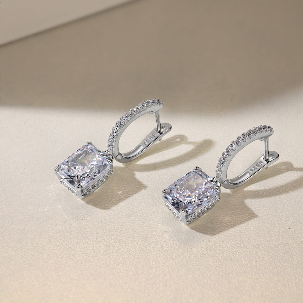 Pair of diamond earrings on a beige background
